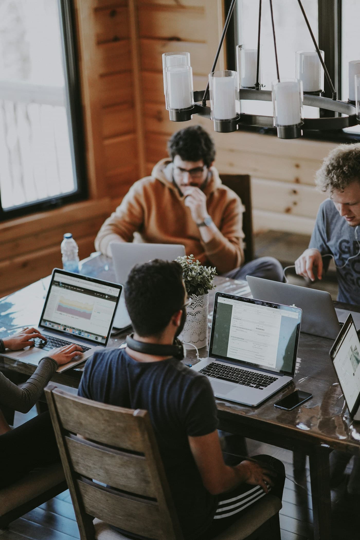 Software engineers working together around a table with laptops